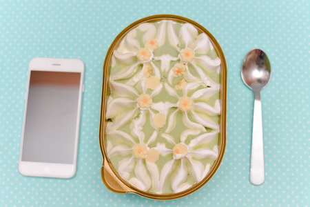 Top view of smart phone and ice cream on table background. Flat lay style
