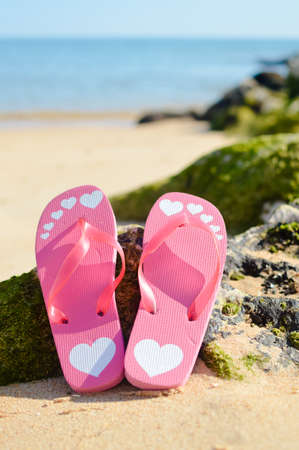 Flip flops on sandy ocean beach background outdoors, warm and nice weather for relaxationの写真素材