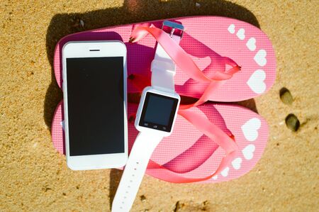 Summer beach with smart phone on sandy outdoors backgroundの写真素材