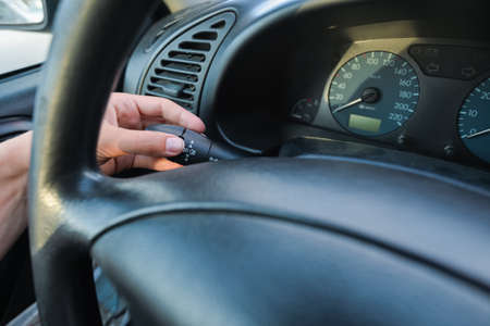 Closeup on female hand driver behind the wheel of a car