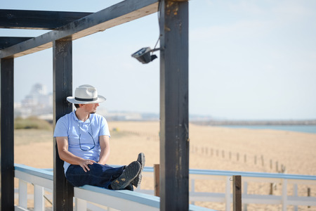 Happy relaxed male looking at the sea from a balcony or terrace on sunny outdoors backgroundの写真素材