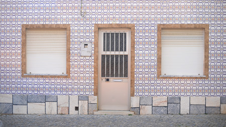 Window with metal shutter on the beautiful brown tiles wall background outdoorsの写真素材