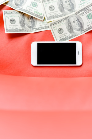 Top view of phone, money bills on red background. Flat lay style closeup, black copy spaceの写真素材