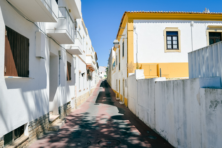 Bright sunny traditional Portuguese street of Albufeira, blue sky backgroundの写真素材