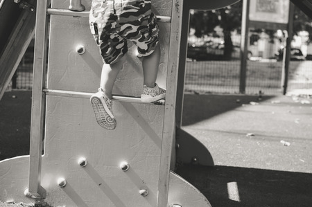 Closeup on child legs active in the playground on city park outdoors backgroundの写真素材