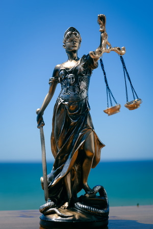 Justice Themis goddess sculpture on bright sky copy space background.の写真素材