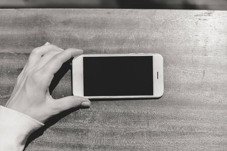 Closeup woman hand using smart phone, top view mock up backgroundの写真素材