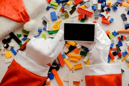 Joyful time and Santa Claus holding mobile smartphone with blank screen background, Closeup image