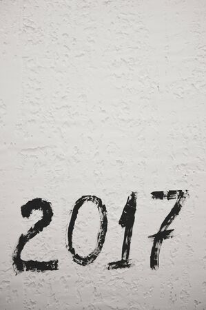 Black and white of 2017 sign symbol on light wall texture copy space