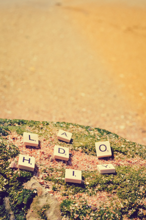Top view on "Holiday" wooden sign pazzle abstract design on the beach backgroundの写真素材