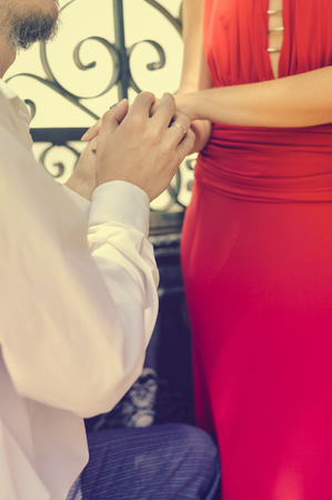 Closeup on hugging couple holding hands sunny outdoors backgroundの写真素材