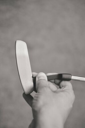Black and white picture of golf club in hand, copyspace background