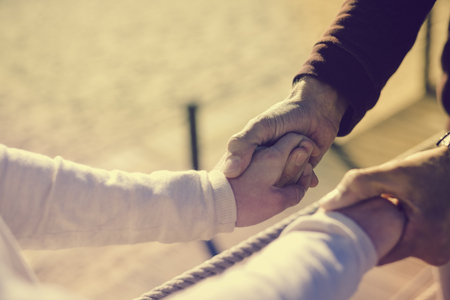 Closeup on couple in love Valentine day background. Happy lovers holding hands together with sunny...