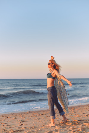 Adult attractive joyful blonde woman in dress on outdoors blue sky background, portraitの写真素材