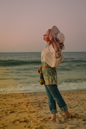 Dawn portrait of beautiful elegant female on the beach outdoors backgroundの写真素材