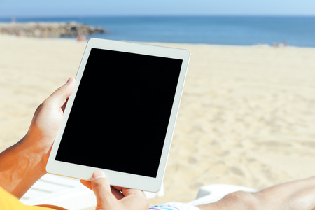 Closeup of man holding in hands using tablet