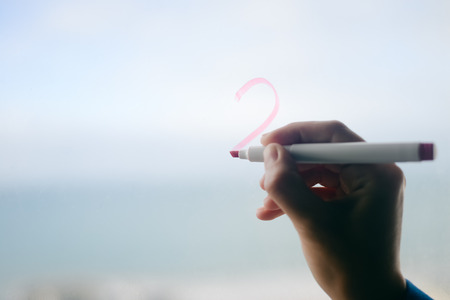 Hand on foggy rainy window, abstract background. Closeup view of emotional feelingsの写真素材