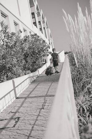 Silhouette of child walking on sunny outdoors background. Back side viewの写真素材