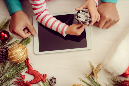 Father with child having fun using wireless technology playing watching media on digital tablet. Top view mockup display closeup festive backgroundの写真素材