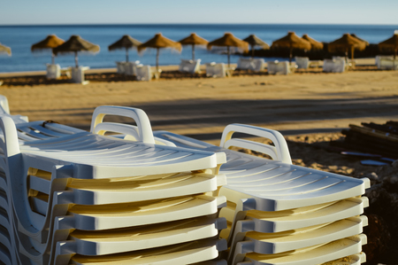 Holiday and vocation image with sandy beach, parasol and chairs on outdoors backgroundの写真素材