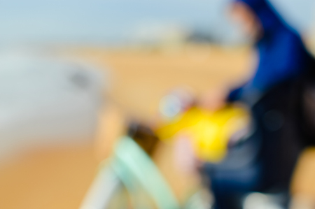 Defocused silhouette of child and father with bike on a beach natural outdoor. Travel vacation backgroundの写真素材