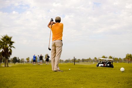 Back view of man on green grass golf field natural outdoors backgroundの写真素材