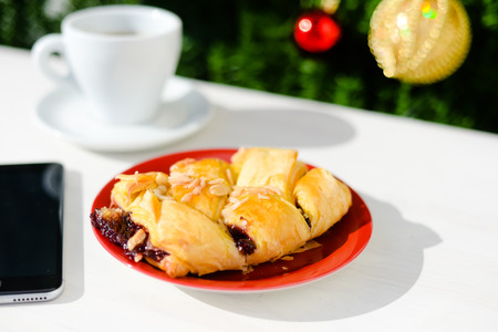 Mobile smartphone, coffee and pastry on light background. Closeup photo flat lay styleの写真素材