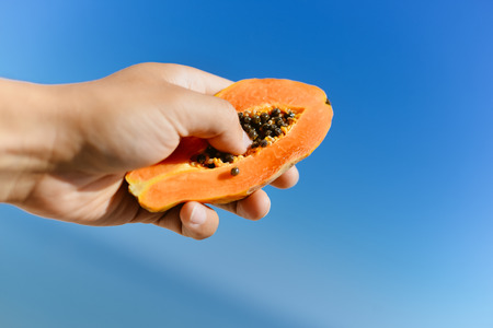 Hands holding tasty papaya fruit, close up image. Healthy lifestyleの写真素材