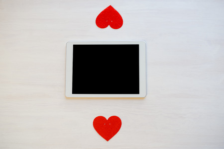 Love is in the Air! Tablet Pc computer with blank screen on hearts background. Valentine day concept...