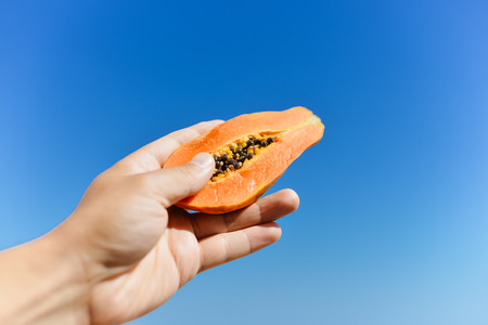 Hands holding tasty papaya fruit, close up image. Healthy lifestyleの写真素材