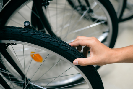 Close up on human hand checking bicycle tireの写真素材