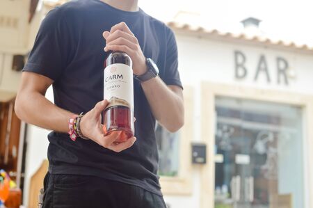 Albufeira, Portugal - August 03, 2016. Person waiter host presenting a wine bottle for tasting
