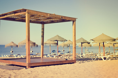 Blue sky and beach umbrella chair on beautiful tropical ocean coastline, sunny outdoors scenic backgroundの写真素材