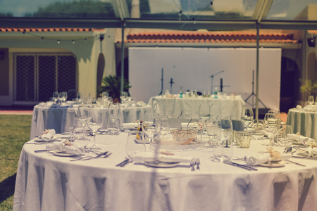 Catered service and tables ready for celebrating food eating event reception, busy light backgroundの写真素材