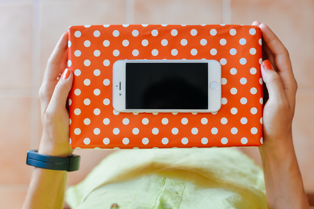 Portugal Europe - August 01, 2016: Happy person holding Apple Iphone 6 mobile phone and parcel deliveries, light backgroundのeditorial素材
