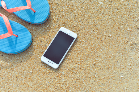 Algarve, Portugal - April 30, 2016: Closeup on iPhone 6 smartphone on the beach background. Top view flat lay style, photo and video outsideのeditorial素材