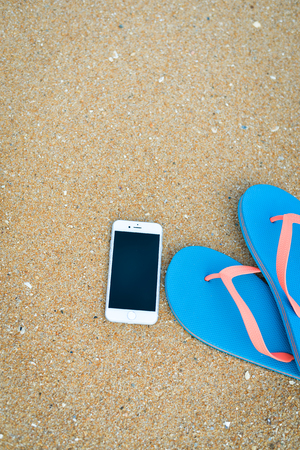 Algarve, Portugal - April 30, 2016: Closeup on iPhone 6 smartphone on the beach background. Top view flat lay style, photo and video outsideのeditorial素材