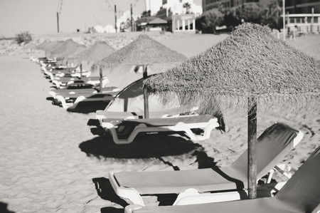 Beach umbrellas and couches on sky outdoors background. Black and white pictureの写真素材