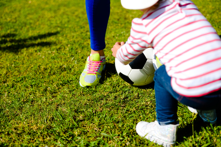 Parents with children playing soccer on green grass nature outdoors background. Childcare, school or weekend activityの写真素材