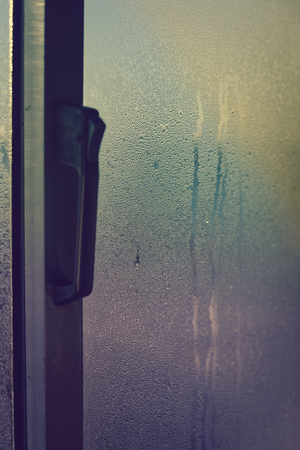 Foggy condensated window blurry textured outdoors background imageの写真素材