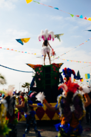 Back view of blurred unrecognizable carnaval parade participants silhouette with colorful feathers. Colorful photoの写真素材