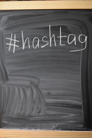 Closeup on hashtag symbol white chalk on a blackboard copy space backgroundの写真素材