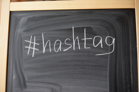 Closeup on hashtag symbol white chalk on a blackboard copy space backgroundの写真素材