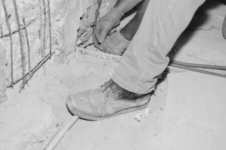 Closeup on hands of working handyman holding tools. Apartment, villa, shop building site background. Business production, health and safety, abstract industry tradeの写真素材