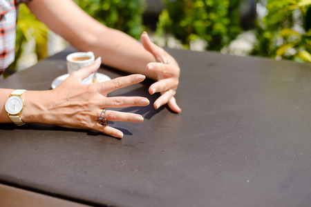 Closeup of female hands, drinking coffee restaurant table background. Close up top side viewの写真素材