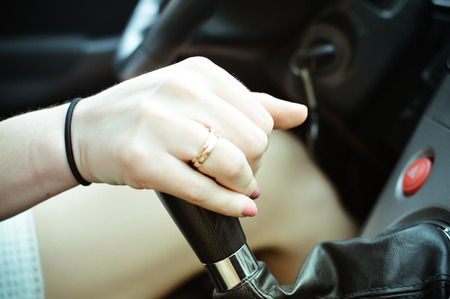 Close-up of a female hand in a modern car over interior backgroundの写真素材