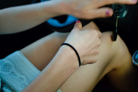 Close-up of a female hand in a modern car over interior backgroundの写真素材