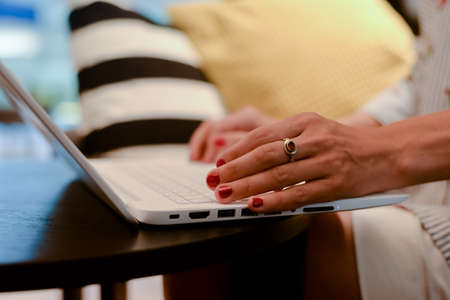 Close up of a woman hands busy typing on a laptop light background. Top side view, copy space photography. Social network communication technologyの写真素材