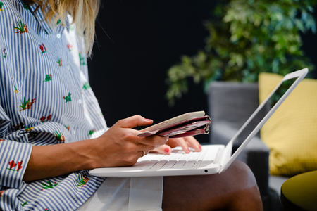 Close up of a woman hands busy typing on a laptop light background. Top side view, copy space photography. Social network communication technologyの写真素材