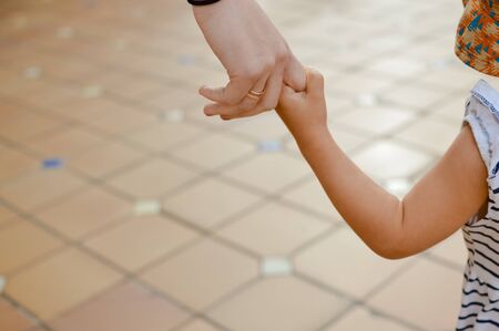 Back view of mother and daughter doing shopping together. Busy joyful time, positive youth people walking on department store background. Enjoying togetherness, education lifestyle activityの写真素材
